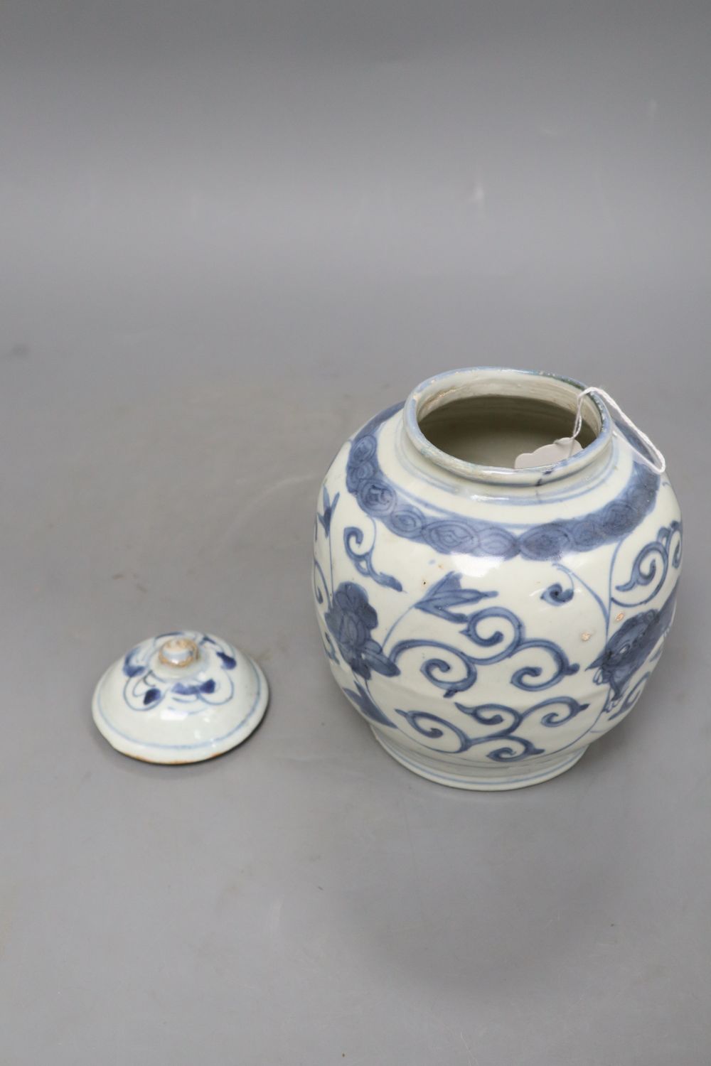 A Chinese Late Ming blue and white lion and lotus jar and cover, overall height 17.5cm, restored rim